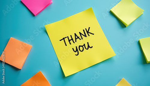 A yellow sticky note with 'Thank you' written on it, surrounded by colorful sticky notes on a blue background