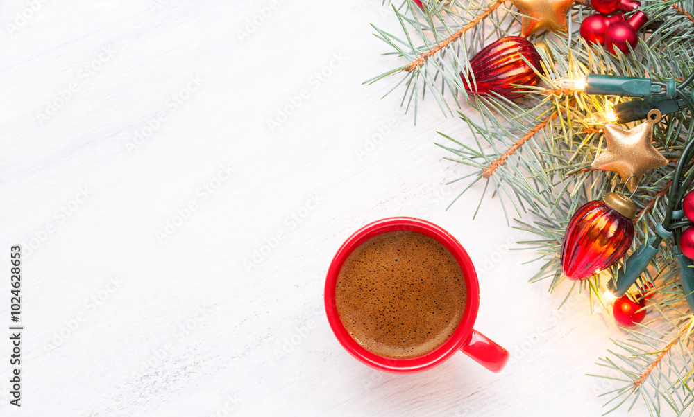 Red cup with coffee and fir branch with Christmas decorations and glowing garland on old wooden shabby white table with empty space for text. Top view.