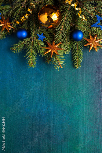 Fir branch with Christmas decorations on a  dark blue-green painted wooden background.  Flat lay.  New Year and Christmas  background.