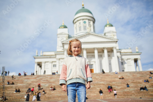 Adorable preschooler girl near Helsinki Cathedral (Helsingin tuomiokirkko) on Senaatintori in Helsinki, Finland photo