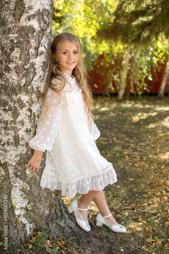 a young girl leaning against a tree with a tree in the background.