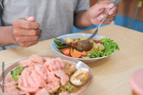 Asian man eating selat solo, javanese food