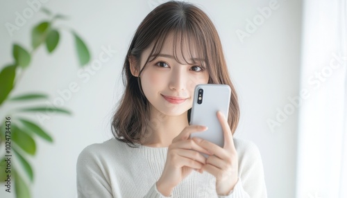 A closeup portrait of a beautiful Japanese woman holding a smartphone