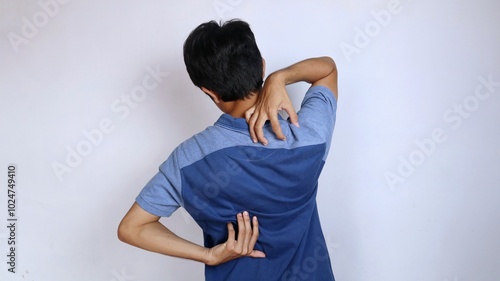 back view of asian young man itching in back area hand gesture scratching back