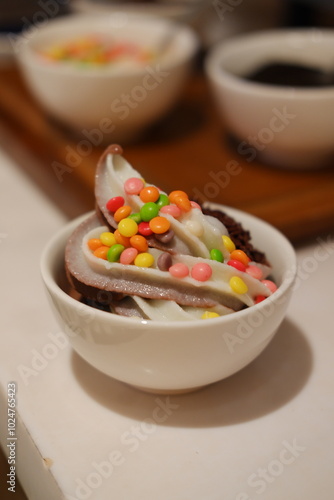 Chocolate ice cream with colorful candies on the white background.