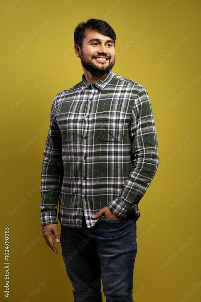man smiling with one hand in his pocket, the other loose and looking to the side man smiling with one hand in his pocket, the other loose and looking to the side