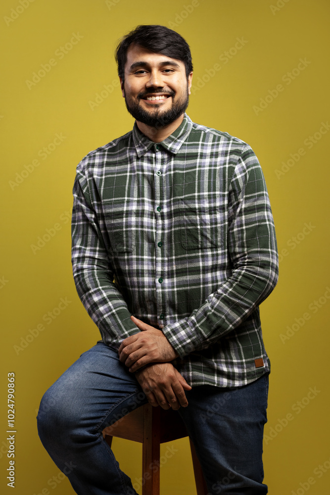 man sitting, smiling, holding his hand man sitting, smiling, holding his hand