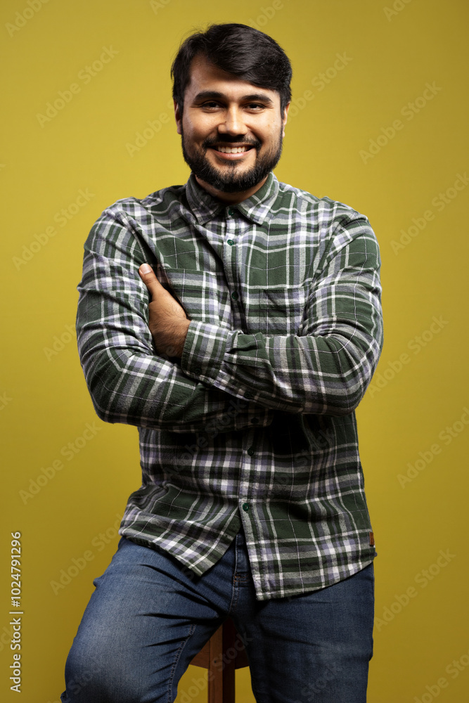 man sitting, with arms crossed, smiling man sitting, with arms crossed, smiling