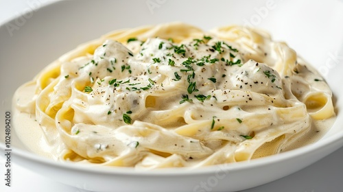 A stunning shot of fettuccine pasta coated in a rich Alfredo sauce, adorned with fresh herbs, elegantly presented against a minimalist white background to highlight the dish's creamy texture.