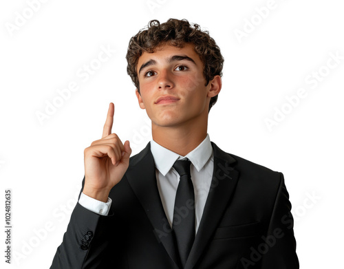 Young man in a black suit gestures confidently while pointing upwards in a ne...