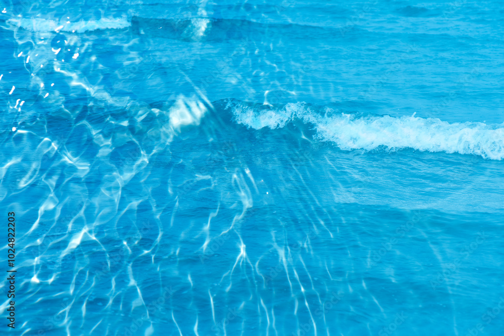 Blue water with ripples on the surface. Defocus blurred transparent blue colored clear calm water surface texture with splashes and bubbles. Water waves with shining pattern texture background. Blue water with ripples on the surface. Defocus blurred transparent blue colored clear calm water surface texture with splashes and bubbles. Water waves with shining pattern texture background.