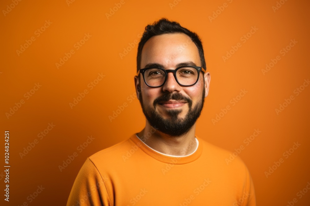 Handsome man with glasses and a orange t-shirt on a orange background Handsome man with glasses and a orange t-shirt on a orange background