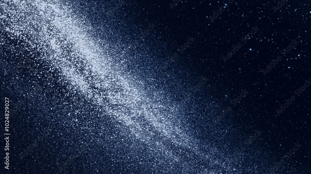 Obraz premium A swirl of white particles spreading against a deep blue sky, resembling the Milky Way. The image evokes a sense of vastness and wonder, symbolizing space exploration and mystery.