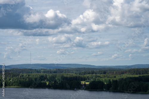 Scenic view of a tranquil lake surrounded by lush forests and cloudy sky photo