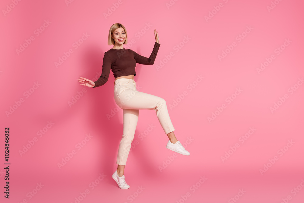 Photo of lovely pretty cute nice girl wear stylish brown clothes step empty space isolated on pink color background Photo of lovely pretty cute nice girl wear stylish brown clothes step empty space isolated on pink color background