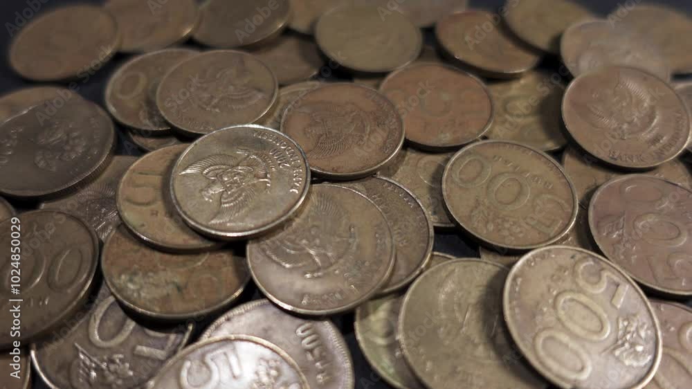 Close up of old Indonesian coin falling on pile. Business finance background Close up of old Indonesian coin falling on pile. Business finance background