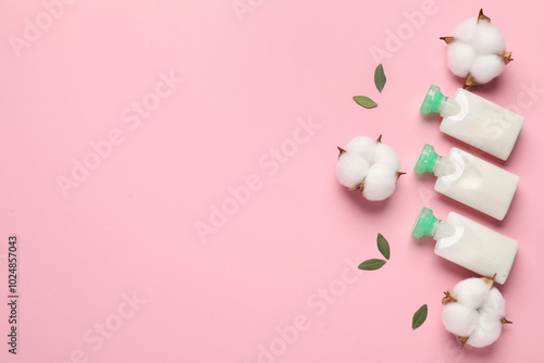 Different cosmetic products, leaves and cotton flowers on pink background, flat lay. Space for text