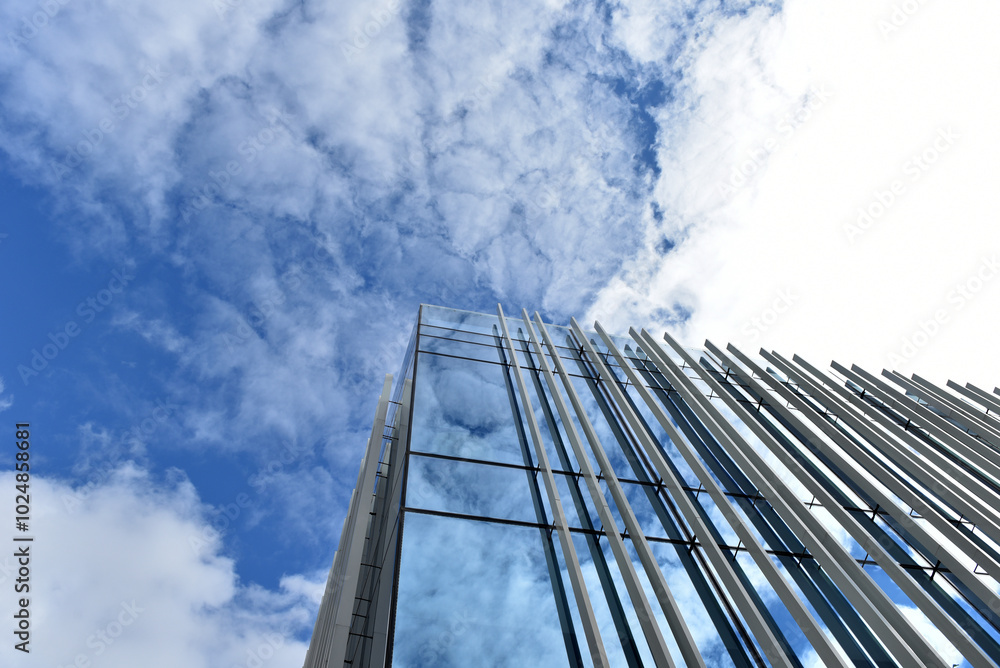 Skyscraper from a low angle view, glass facade against blue sky Skyscraper from a low angle view, glass facade against blue sky