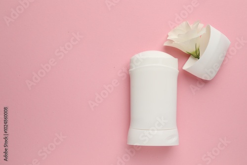 Solid deodorant and beautiful eustoma flower on pink background, top view. Space for text photo