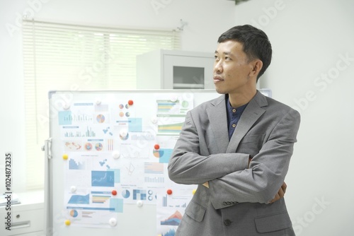 Wallpaper Mural Portrait of a handsome smiling Asian businessman in a suit standing in a corporate office. Torontodigital.ca