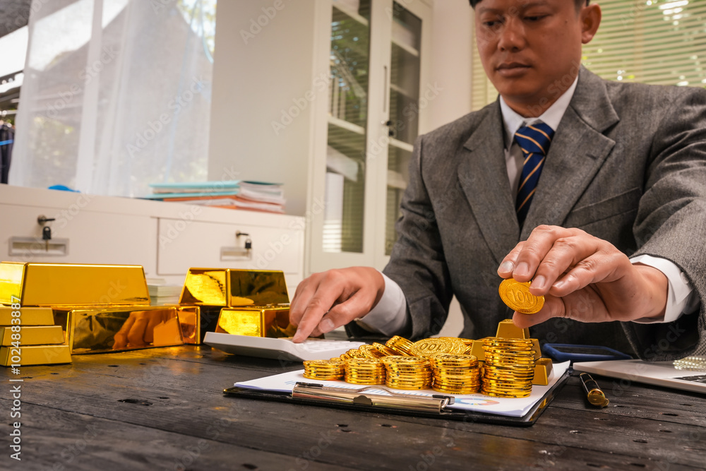 Businessman doing online gold transactions emphasizes the convenience of investing in digital gold. Businessman holds shiny gold bars in office, symbolizing wealth and investment opportunities. Businessman doing online gold transactions emphasizes the convenience of investing in digital gold. Businessman holds shiny gold bars in office, symbolizing wealth and investment opportunities.