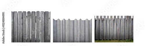 A weathered grey wooden fence stretches across the frame, with a patch of green grass at the bottom.