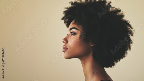 Profile of a young woman with natural hair, side view against a plain background, minimalistic portrait.