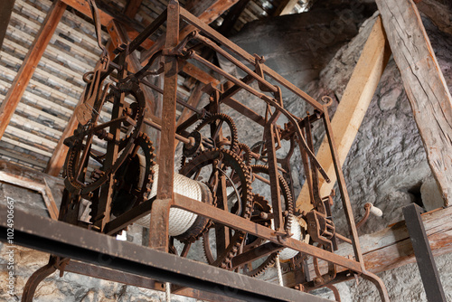 Ancient mechanical lifting mechanism with rusty gears, ancient winch.