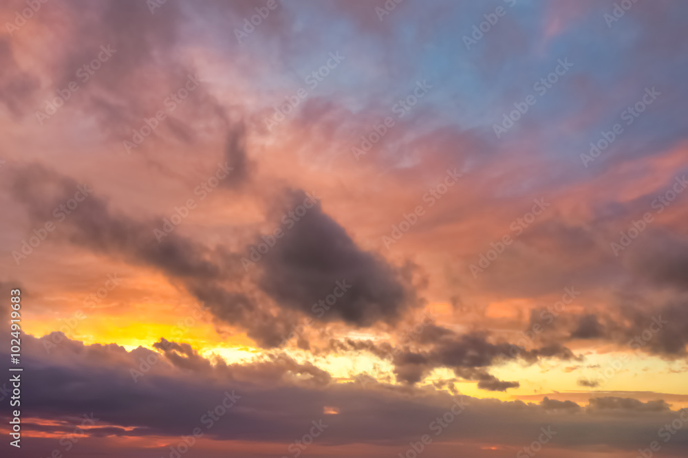Fototapeta premium A beautiful sky tinted by the sun leaving vibrant shades of gold, pink, blue and multicolored. Clouds in the twilight evening and morning sky. Cloudy sky background in the evening, and during the day.