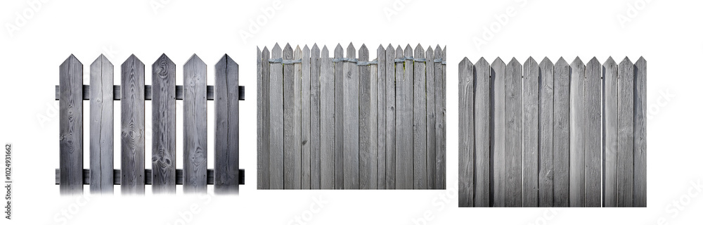 A weathered gray wooden fence with pointed top slats A weathered gray wooden fence with pointed top slats