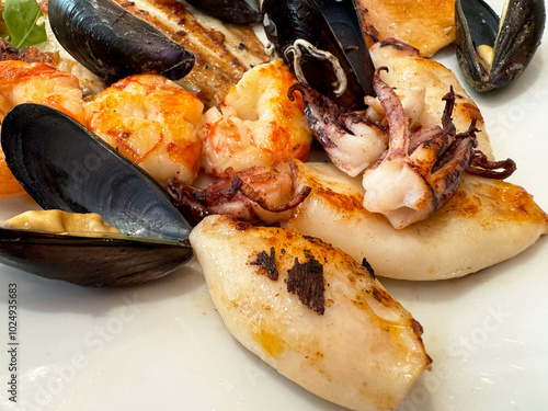 Delicious grilled seafood platter with mussels, squid, and shrimp photo