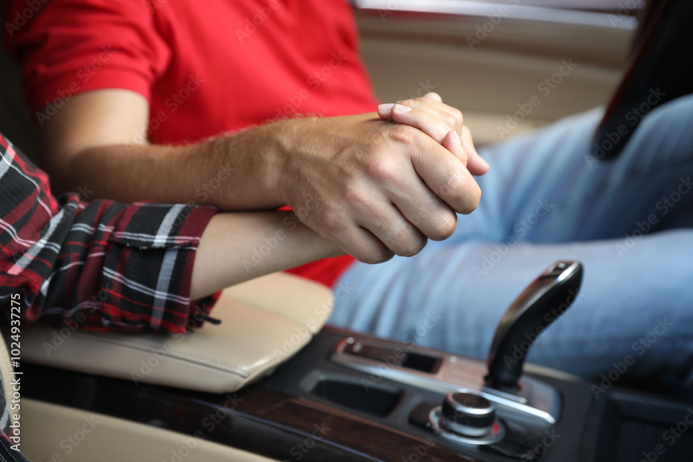 Lovely couple holding hands together while traveling by car, closeup Lovely couple holding hands together while traveling by car, closeup