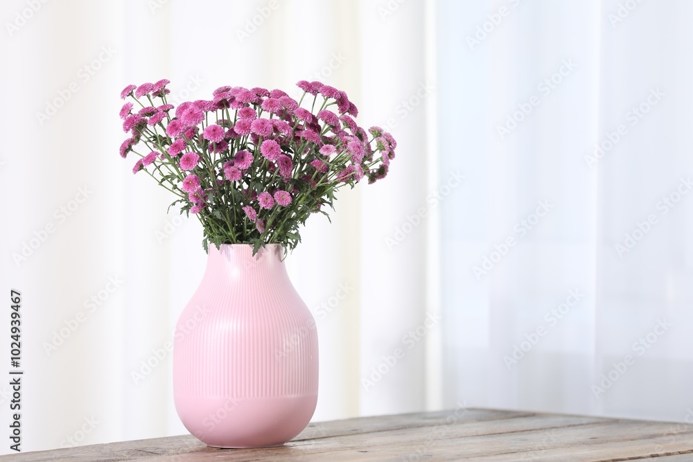 Beautiful pink flowers in vase on wooden table indoors. Space for text Beautiful pink flowers in vase on wooden table indoors. Space for text