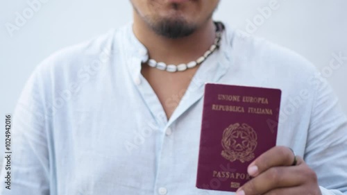 Latino immigrant showing his italian passport with pride close up. Immigration opportunities job concept