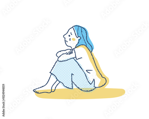 膝を抱えて泣いている女性