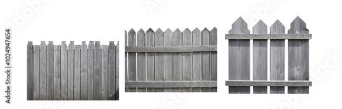 Three sections of a weathered gray wooden fence with pointed tops