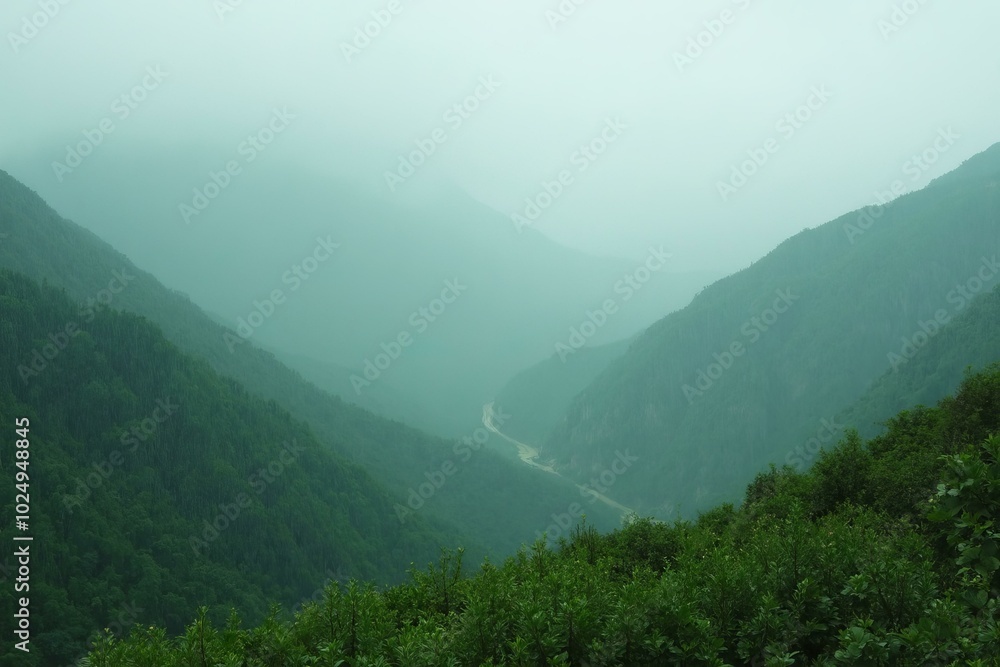 Fototapeta premium Green Mountains On A Misty Day With Winding Road And Lush Vegetation