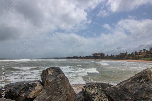 Beach, with lava rocks and vegetation, view of the sea in the evening at sunset. Landscape with clouds in Induruwa, Bentota Beach, Sri Lanka, India, Asia photo