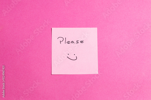 A pink background with a smiley face and the word "please" written on it