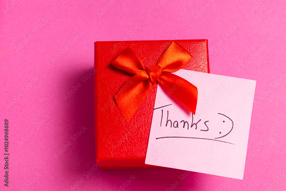 A red box with a red bow and a pink background A red box with a red bow and a pink background