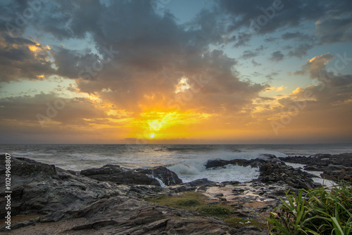 Beach, with lava rocks and vegetation, view of the sea in the evening at sunset. Landscape with clouds in Induruwa, Bentota Beach, Sri Lanka, India, Asia