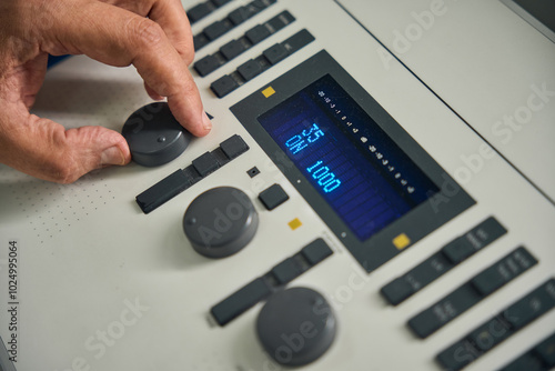 Caucasian doctor adjusting settings on an audiometer photo