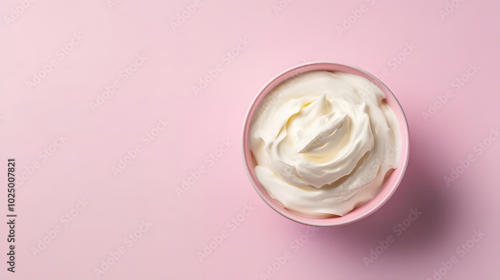 3. A minimalistic top view of a bowl of sour cream on a subtle pastel background, showcasing the texture and smoothness of the cream, with clear copy space for promotional use
