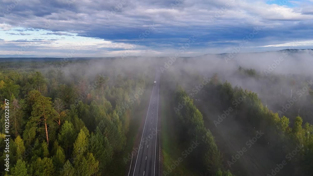 A truck and cars are driving along a beautiful road A truck and cars are driving along a beautiful road