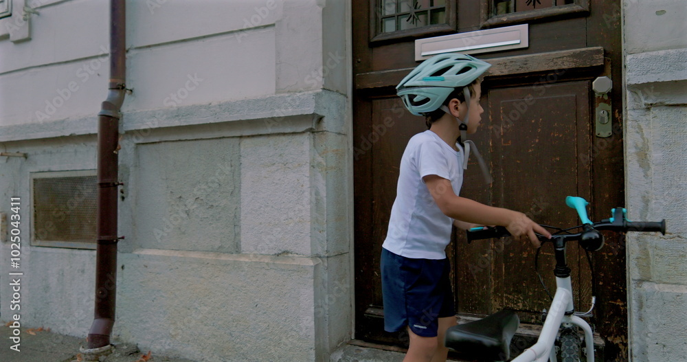 Boy securing his bicycle outside a building, wearing a helmet, showcasing responsible and independent outdoor activities for children, emphasizing safety and exploration in an urban environment Boy securing his bicycle outside a building, wearing a helmet, showcasing responsible and independent outdoor activities for children, emphasizing safety and exploration in an urban environment