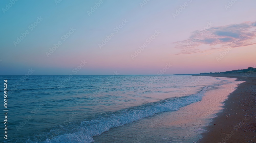 Fototapeta premium 美しい夕暮れ時の海岸で、穏やかな波が打ち寄せる風景を楽しむ瞬間