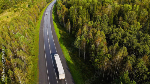 A truck and cars are driving along a beautiful road