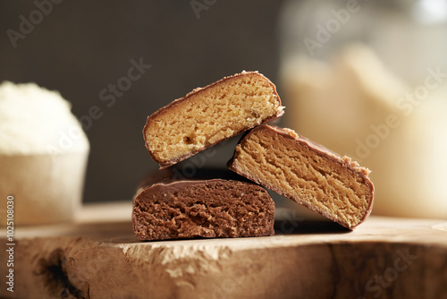 Vegetarian protein chocolate bars with a jar of whey protein powder in the background