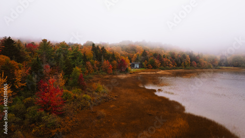 Connery Pond, New York, USA - October 3rd, 2021 - Aerial View Autumn Fall Season Lake House Colorful Forest Trees Remote Getaway Foggy Moody Scene photo