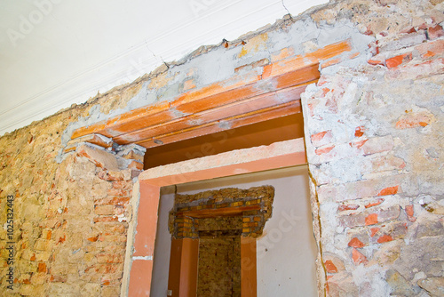 New reinforced brick lintel useful for creating a new door, or a new window, in an old stone and brick wall in a construction site photo